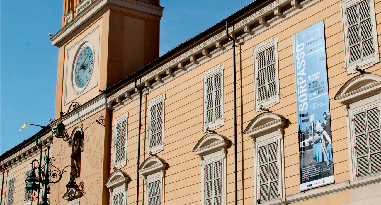 Lo stendardo della mostra il Sorpasso sulla facciata del Palazzo del Governatore a Parma